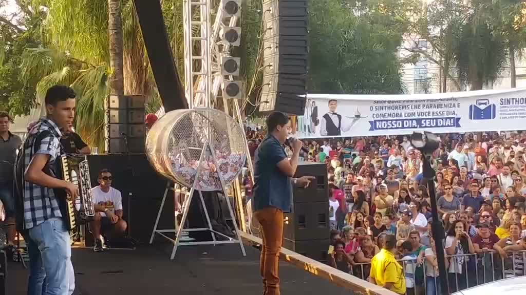 Diego Simonete no palco diante de grande público em praça, com faixas de sindicatos ao fundo